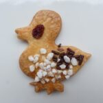 Pettirosso infreddolito su un balcone con biscotti sbriciolati accanto a lui.