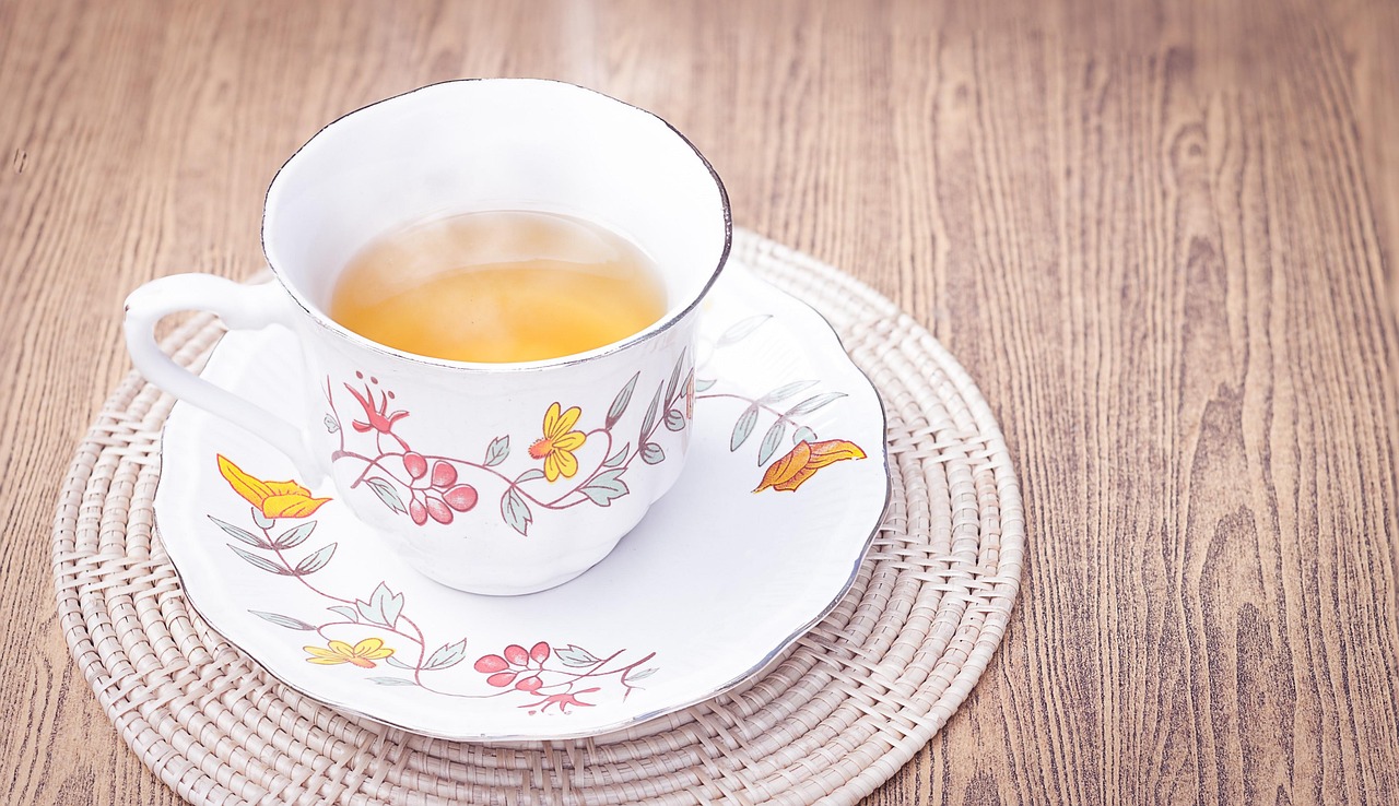 Tazza di tè fumante su un tavolo, pronta per essere gustata al mattino per aiutare a sciogliere i grassi addominali.