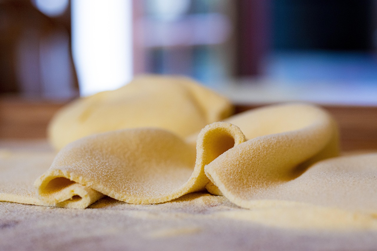 Tortelli di zucca mantovani serviti con burro fuso e salvia in un piatto bianco.