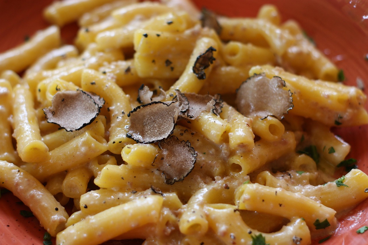 Pasta al tartufo servita in un piatto elegante, con decorazioni di erbe fresche.